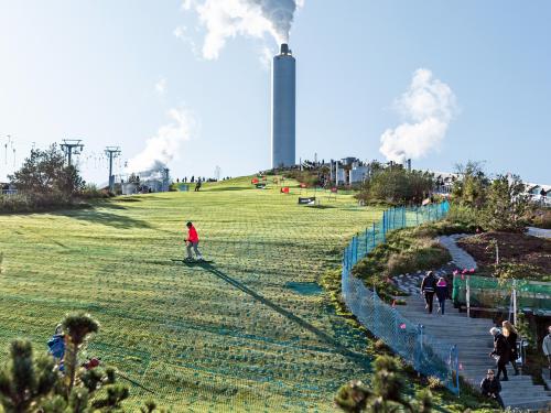 People skiing on synthetic mats on a pitched green roof